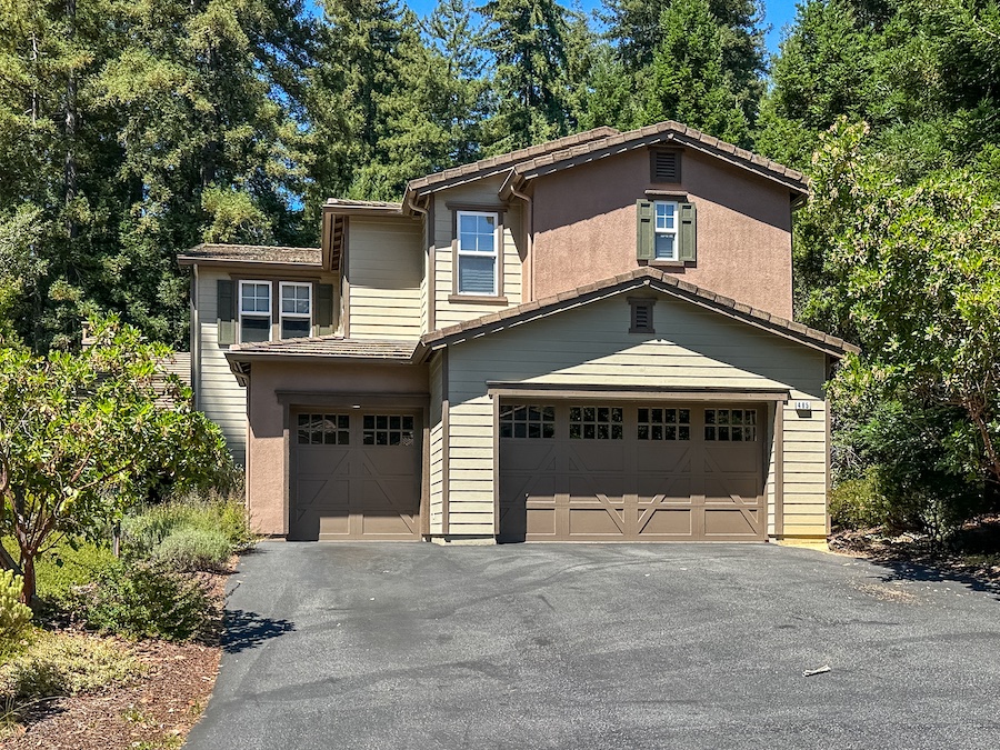 Tan home with one double and one single garage door